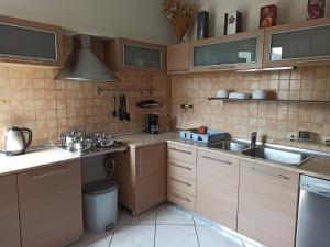 a kitchen with wooden cabinets and a sink at Διαμέρισμα 110 Μ στον Λαγκαδά in Lagadas