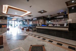 a fast food restaurant with a counter and a person at فندق غالية احد in Al Madinah