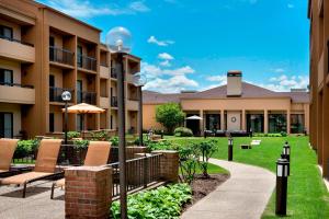 a courtyard at a hotel with chairs and an umbrella at Courtyard by Marriott Chicago Waukegan / Gurnee in Waukegan