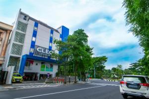 a car parked in front of a building on a street at Cleo Business Hotel Walikota Mustajab City Center in Surabaya