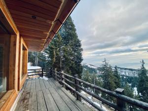 una terraza de madera con vistas a las montañas en Čudovita koča na samem, Gorenka, en Cerklje na Gorenjskem