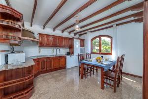 a kitchen with wooden cabinets and a table with chairs at VV Makita by HH in Playa Blanca