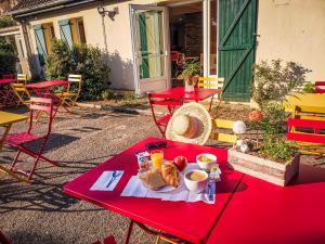 una mesa roja con un plato de comida. en Première Classe Metz Nord - Talange, en Talange