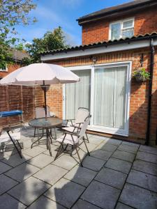 a patio with a table and chairs and an umbrella at Home away from Home in Woolwich