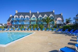 a large building with chairs and a swimming pool at L' Eclose Cap Marine in Le Guilvinec