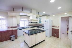 una grande cucina con elettrodomestici bianchi e frigorifero bianco di lujosa villa en Alhaurin de la Torre 7 dormitorios ad Alhaurín de la Torre