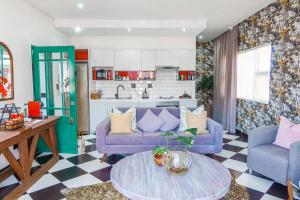 a living room with two purple couches and a table at 55 on Main in Fish hoek