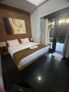 a bedroom with a large bed and a window at Rahayu Guest House Seminyak in Seminyak