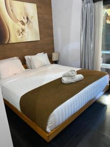 sypialnia z dużym łóżkiem z białą pościelą w obiekcie Rahayu Guest House Seminyak w mieście Seminyak