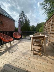 a patio with a table and chairs on a deck at Studio 8 in Sancourt