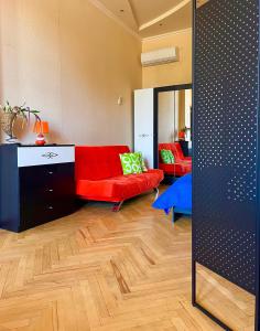 sala de estar con sofá rojo y espejo en Old Ubani Apartment, en Tiflis