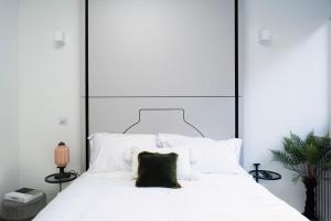 Spacious Studio Apartments at Dandi on The Hill في هارو: غرفة نوم مع سرير أبيض كبير مع اللوح الأمامي الأسود