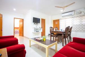 uma sala de estar com um sofá vermelho e uma mesa em Hotel TamilNadu, Madurai II em Madurai