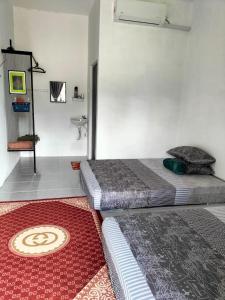 Kampong MerbokにあるDe Hampar Homestayの赤いカーペットフロアのベッドルーム1室(ベッド2台付)