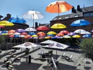 a bunch of umbrellas hanging above chairs and tables at Loft in Borgloon in Borgloon