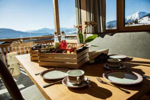 a table with plates and utensils on a table with a view at Kieserhof Apartment Alm in Terento