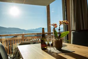 una mesa con una botella de vino y copas en el balcón en Kieserhof Apartment Wald, en Terento