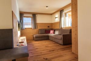 a living room with a couch and a tv at Kieserhof Apartment Alm in Terento