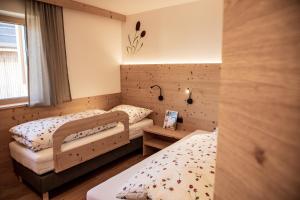 a bedroom with two beds and a window at Kieserhof Apartment Alm in Terento