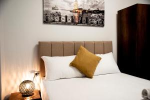 - un lit avec des oreillers blancs et un tableau mural dans l'établissement CK Boutique Hotel, à Istanbul