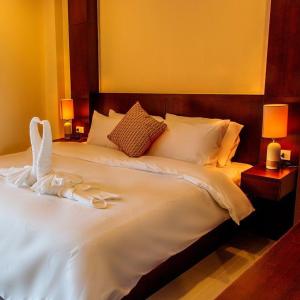 a bedroom with a large white bed with two lamps at Lucky inn Residency in Pattaya South