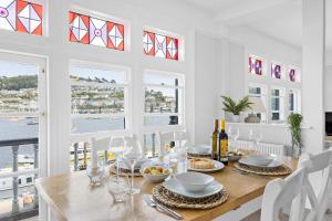 a dining room with a table and chairs and windows at THE ANGEL 2 BEST VIEWS IN DARTMOUTH in Dartmouth