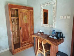 a wooden table in a room with a mirror at Nirmala Guest House in Ubud