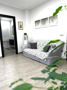 ein weißes Zimmer mit einem Bett und einem Spiegel in der Unterkunft Le Mandorle Apartment in Belpasso