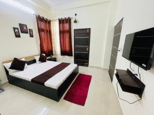a bedroom with a large bed and a red rug at ATULYAM STAYS SUSHANT GOLF CITY LUCKNOW in Lucknow