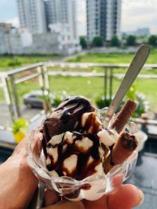 a person holding a chocolate dipped ice cream dessert at ATULYAM STAYS SUSHANT GOLF CITY LUCKNOW in Lucknow