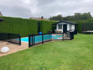 a black fence in a yard with a swimming pool at Annexet in Hässleholm