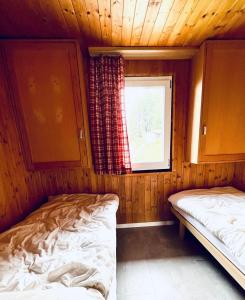 FlumserbergにあるChalet Wiesehockli - CharmingStayのベッド2台付きの客室で、キャビン内に窓があります。
