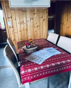 a table with a red and white table cloth on it at Chalet Wiesehockli - CharmingStay in Flumserberg