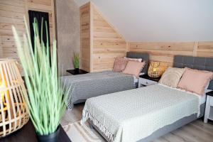 2 Betten in einem Zimmer mit Holzwänden in der Unterkunft Ranczo Słajszewo in Słajszewo