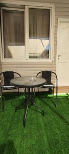 Ma‘alot的住宿－Montfort Weekend，绿草门廊上的一张桌子和两把椅子
