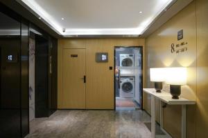 a hallway with a laundry room with a washer and dryer at Paco Hotel Jiangtai Lu Metro Guangzhou ---Free Shuttle Bus For CantonFair in Guangzhou