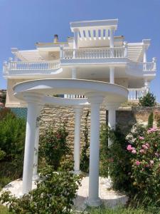 a white house with a balcony on top of it at Villa Ulyana Kriaritsi - Athos Sea View & Spa in Kriaritsi
