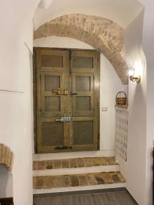 a large wooden door in a room with stairs at Casa Giovannina in Bernalda