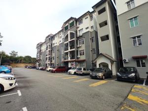 セパンにあるBunga Homestay KLIA Sepangの高層ビルの隣に車を停めた駐車場