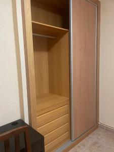 a empty closet with a wooden cabinet and a table at Habitación económica en Madrid Sur in Getafe
