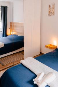 - une chambre avec 2 lits et un miroir dans l'établissement Il Nido Luminoso Acquario-Genova Centro Storico, à Gênes