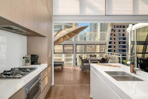 a kitchen with a sink and a stove top oven at Luxury Loft in the CBD with Outdoor Living in Sydney