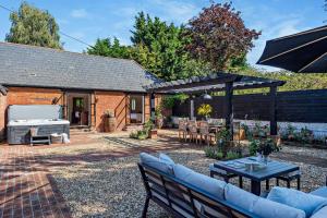 a patio with a grill and a table and chairs at The Willows by Bloom Stays in Ash