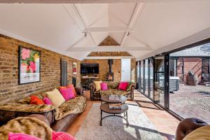 a living room with couches and a brick wall at The Willows by Bloom Stays in Ash