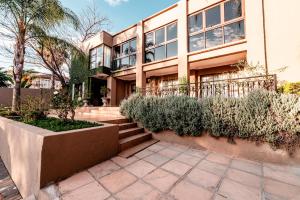 a house with stairs and plants in front of it at Château La Mer Exclusive Guesthouse & Spa in Hartbeespoort