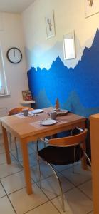 una mesa con 2 sillas y una pared azul en FeWo Hirschblick, en Brilon