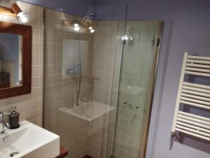 een badkamer met een glazen douche en een wastafel bij Llar compartida El Tupí in Sant Juliá de Vilatorta