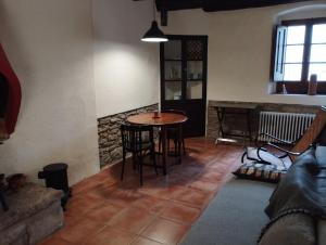 een woonkamer met een tafel en stoelen en een bank bij Llar compartida El Tupí in Sant Juliá de Vilatorta