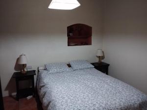 a bedroom with a bed with two lamps on tables at Llar compartida El Tupí in Sant Juliá de Vilatorta