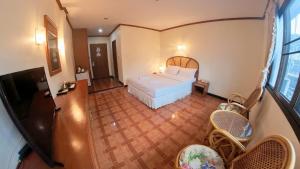 een slaapkamer met een bed bij Roongruang Hotel in Chiang Mai